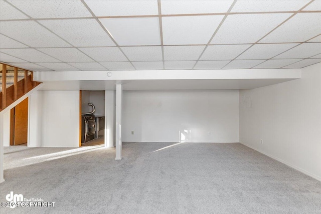 basement featuring carpet floors and a paneled ceiling