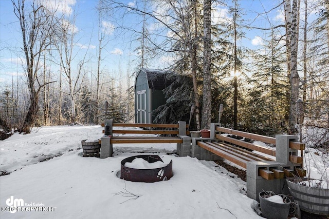 yard covered in snow with an outdoor fire pit