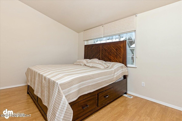 bedroom with lofted ceiling and light hardwood / wood-style flooring