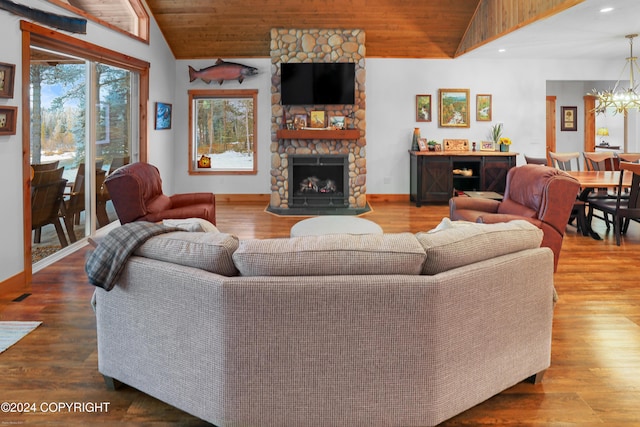 34184 House Dr, Soldotna, AK 99669 - living area with vaulted ceiling, a chandelier, wooden ceiling, a stone fireplace, and wood finished floors