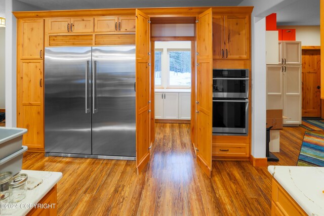 34184 House Dr, Soldotna, AK 99669 - kitchen with appliances with stainless steel finishes, wood finished floors, and light countertops