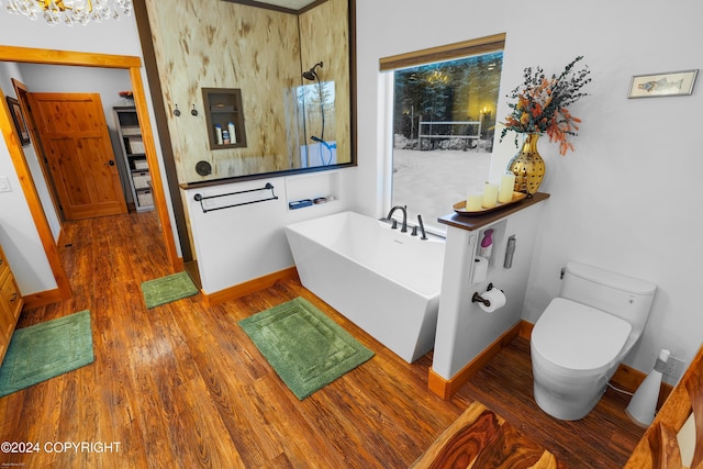 34184 House Dr, Soldotna, AK 99669 - full bathroom featuring a freestanding bath, wood finished floors, baseboards, and toilet