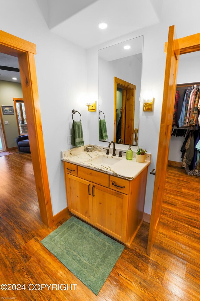 34184 House Dr, Soldotna, AK 99669 - bathroom with vanity, wood finished floors, baseboards, a spacious closet, and recessed lighting