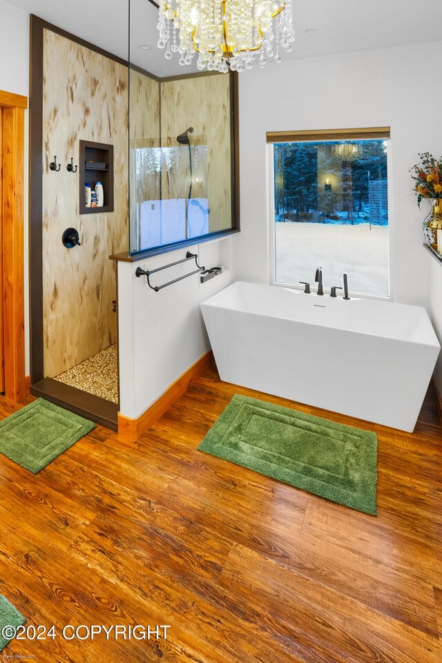 34184 House Dr, Soldotna, AK 99669 - bathroom featuring a chandelier, a walk in shower, a freestanding bath, and wood finished floors