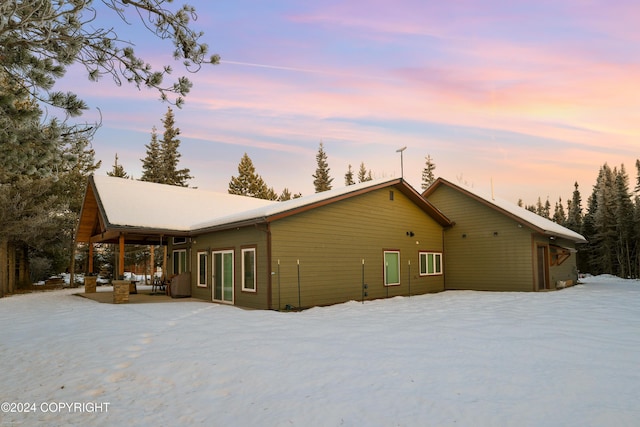 34184 House Dr, Soldotna, AK 99669 - snow covered back of property with an outdoor hangout area and a patio