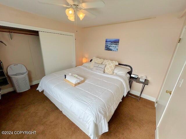 bedroom featuring ceiling fan, a closet, and dark carpet