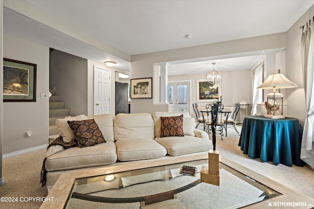 carpeted living room with an inviting chandelier