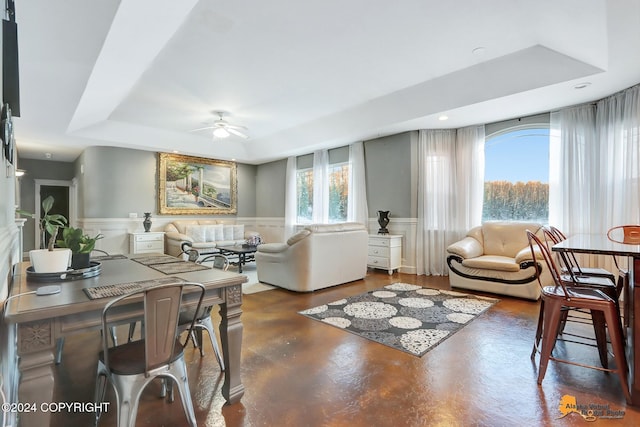 living room featuring a tray ceiling and ceiling fan