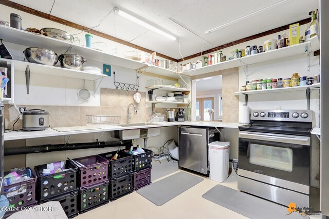 kitchen featuring backsplash, sink, concrete flooring, and appliances with stainless steel finishes