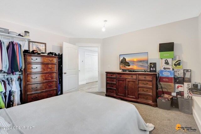 bedroom with light carpet and a closet