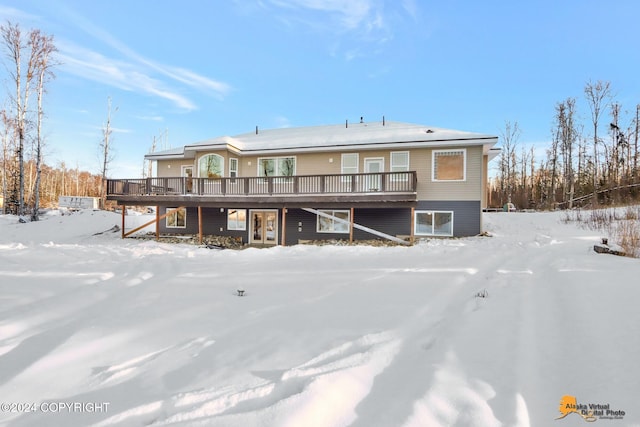 snow covered rear of property featuring a deck