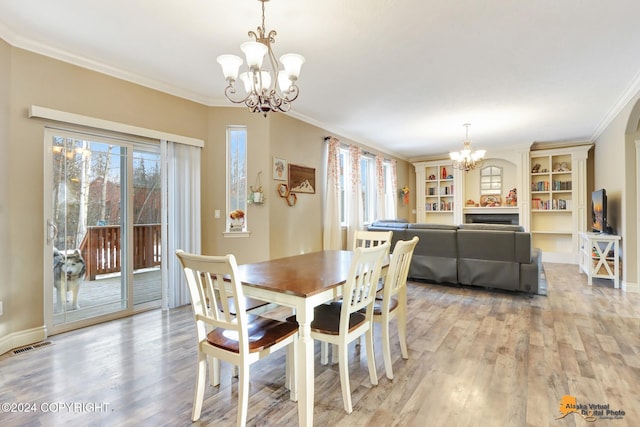 dining space featuring a chandelier, crown molding, and light hardwood / wood-style floors