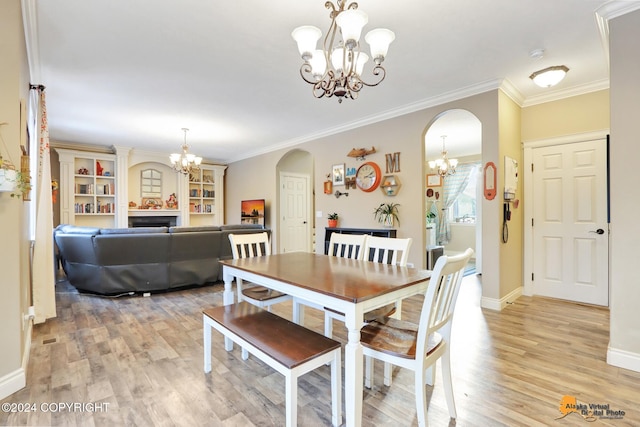 dining room featuring a large fireplace, crown molding, and light hardwood / wood-style flooring