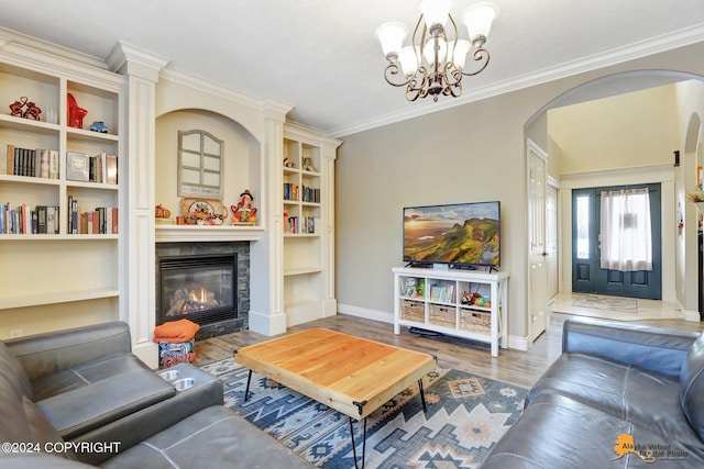 living room with hardwood / wood-style flooring, ornamental molding, and an inviting chandelier