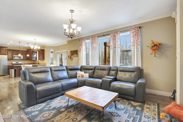 living room featuring a chandelier, dark hardwood / wood-style flooring, ornamental molding, and sink