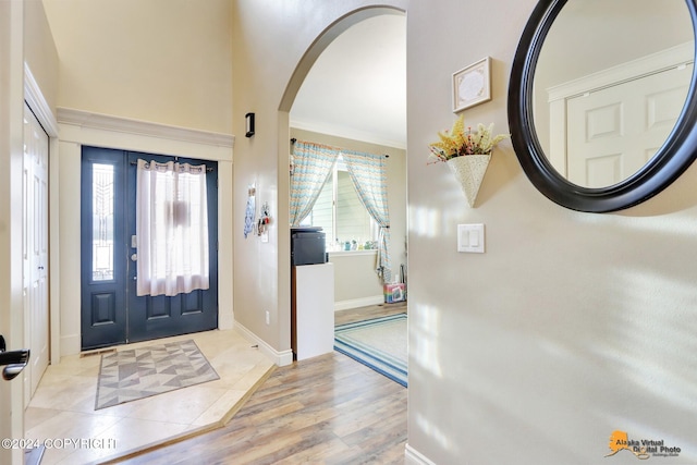 foyer entrance with ornamental molding and light hardwood / wood-style flooring