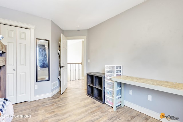 unfurnished office with light wood-type flooring and built in desk