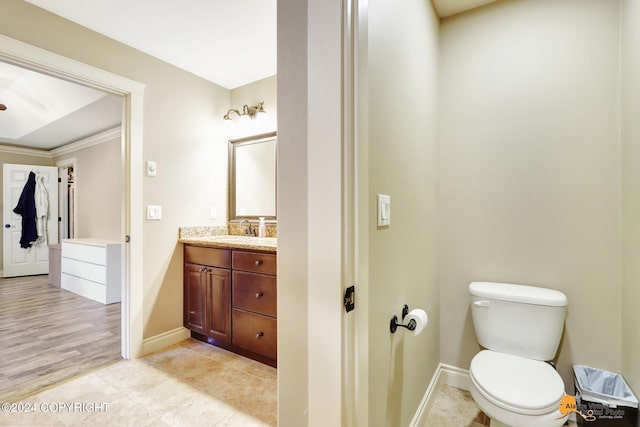 bathroom with vanity, hardwood / wood-style flooring, toilet, and ornamental molding