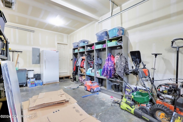 garage with electric panel and white refrigerator