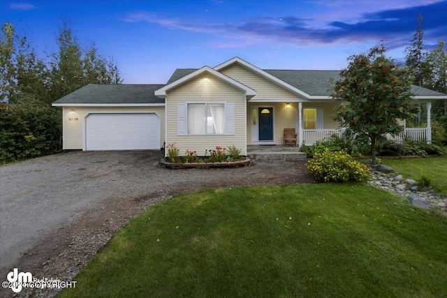 ranch-style home featuring a yard, a garage, and a porch