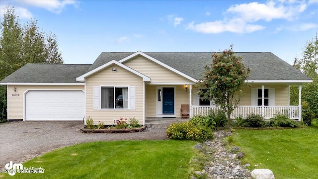 view of front facade featuring a garage, covered porch, and a front lawn