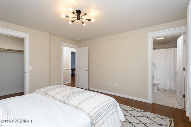 bedroom featuring connected bathroom, dark hardwood / wood-style floors, and a closet