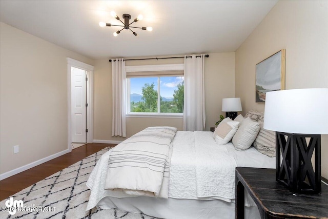 bedroom with dark hardwood / wood-style floors and a chandelier