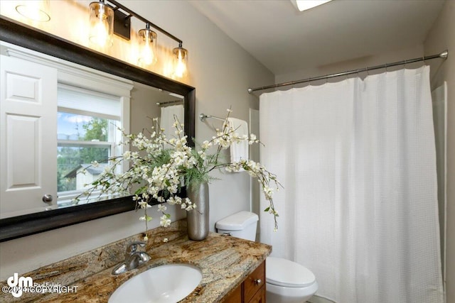 bathroom featuring a shower with curtain, vanity, and toilet