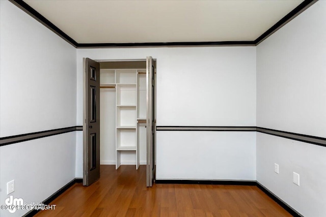 unfurnished bedroom with hardwood / wood-style flooring and ornamental molding