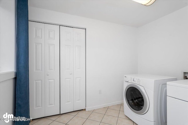 laundry area with light tile patterned flooring and washer / clothes dryer