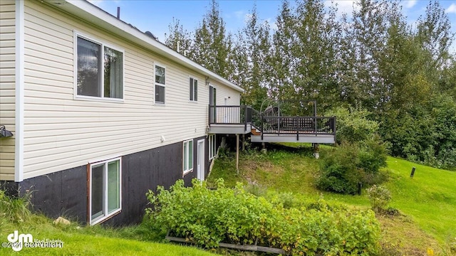 view of side of property with a wooden deck and a lawn