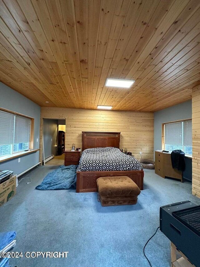 bedroom featuring wood walls, wooden ceiling, baseboard heating, and carpet floors