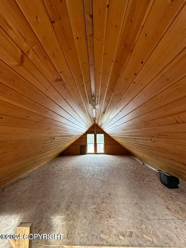 additional living space with wooden walls, lofted ceiling, and wood ceiling