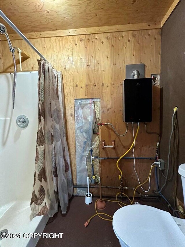 bathroom featuring wood walls and toilet