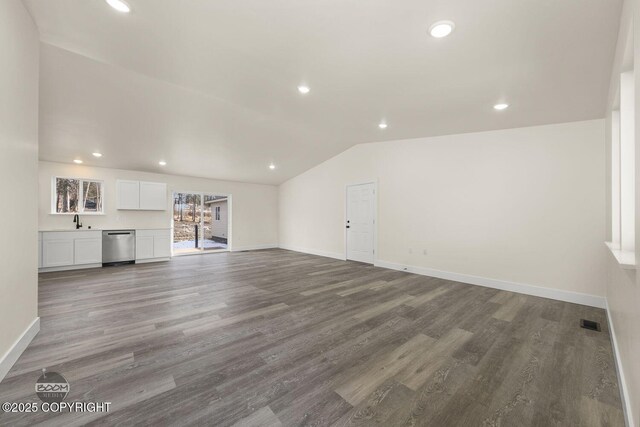 4980 Kelsi Loop, Wasilla, AK 99654 - unfurnished living room with lofted ceiling, wood finished floors, baseboards, and a sink