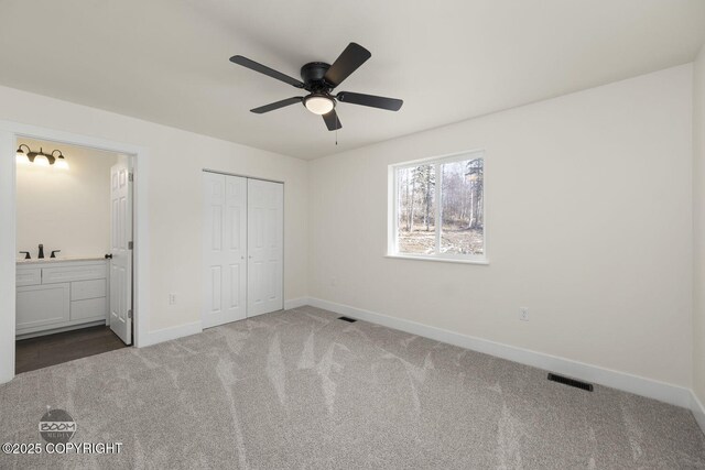4980 Kelsi Loop, Wasilla, AK 99654 - unfurnished bedroom with visible vents, baseboards, ensuite bathroom, and carpet flooring