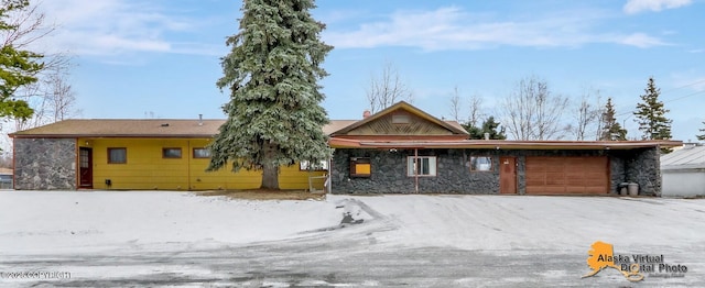 view of front facade with an attached garage and stone siding