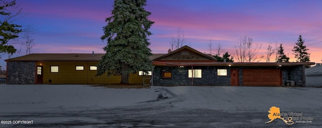 view of front of home featuring a garage and stone siding