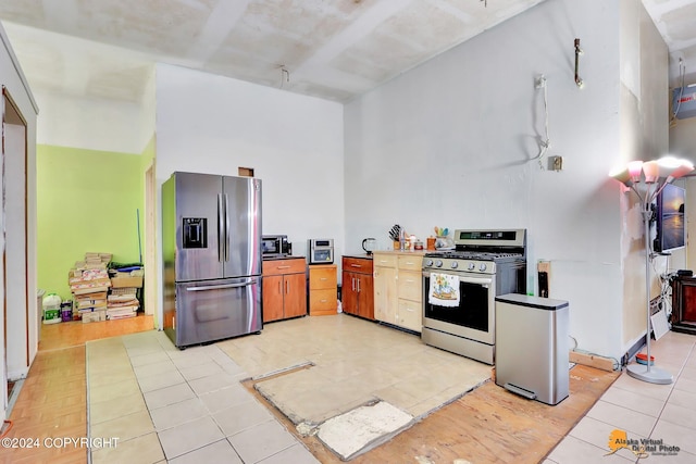 kitchen with light tile patterned floors and stainless steel appliances