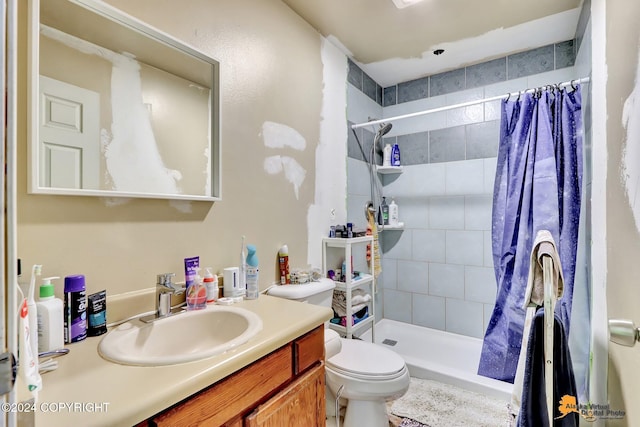 bathroom featuring a shower with shower curtain, vanity, and toilet