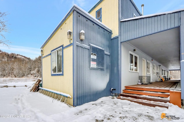 view of snowy exterior featuring a wooden deck