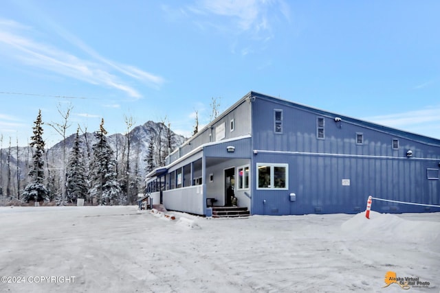 snow covered rear of property with a mountain view