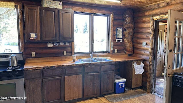 68537 Veater Ave, Ninilchik, AK 99639 - kitchen featuring gas range, rustic walls, a sink, butcher block counters, and light wood-type flooring