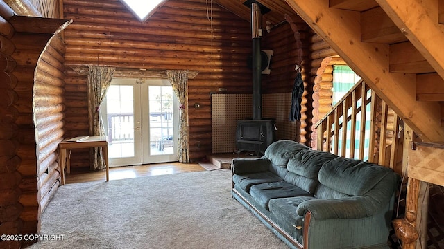 68537 Veater Ave, Ninilchik, AK 99639 - living area with french doors, healthy amount of natural light, a wood stove, log walls, and wood finished floors