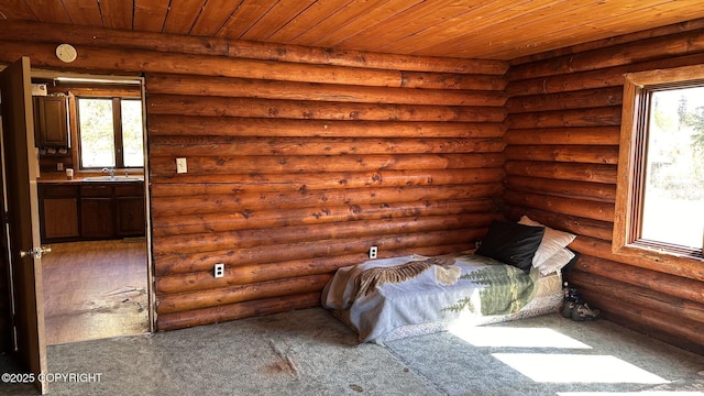 68537 Veater Ave, Ninilchik, AK 99639 - unfurnished bedroom with log walls, multiple windows, wooden ceiling, a sink, and dark carpet