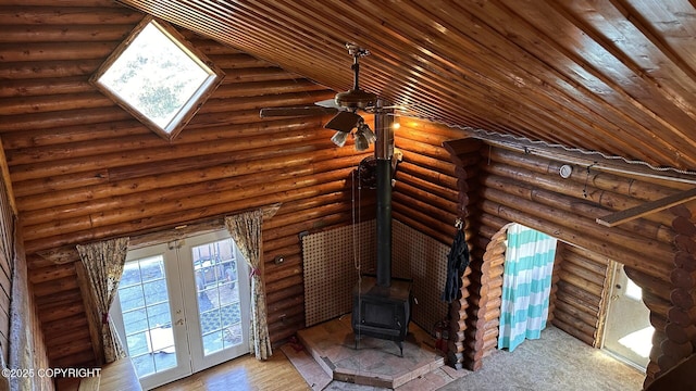 68537 Veater Ave, Ninilchik, AK 99639 - unfurnished living room featuring plenty of natural light, a wood stove, rustic walls, and french doors