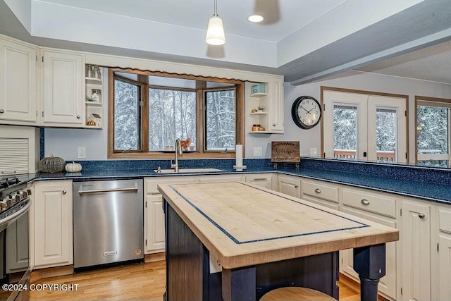 kitchen featuring white cabinets, sink, light hardwood / wood-style flooring, appliances with stainless steel finishes, and a kitchen island