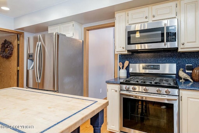 kitchen with white cabinetry, decorative backsplash, and appliances with stainless steel finishes