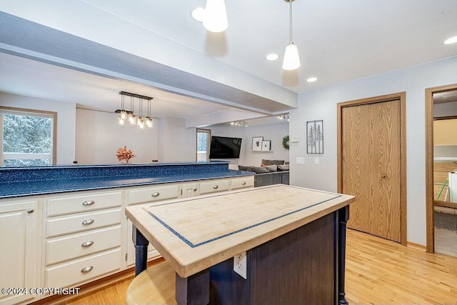 kitchen featuring hanging light fixtures, a kitchen island, and light hardwood / wood-style floors