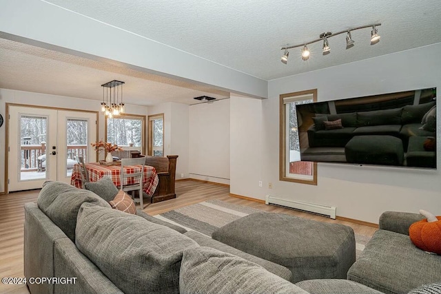 living room featuring french doors, a textured ceiling, a baseboard radiator, and light hardwood / wood-style flooring